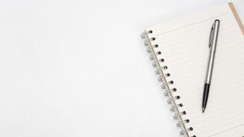 Silver pen and notebook blank page on the table top view copy space photo