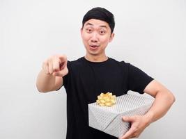 Asian man holding gift box and point finger at you happy new year concept photo