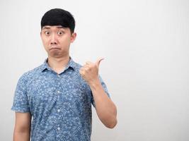 Asian man blue shirt feeling amazed point finger at copy space photo