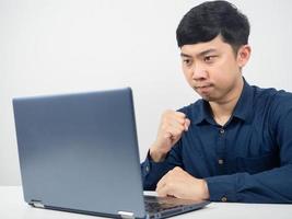 Man gesture confident show fist up looking at laptop on the table