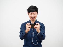 hombre asiático usando un juego de auriculares en el teléfono móvil sintiéndose divertido fondo blanco foto