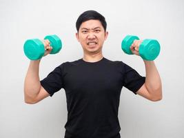 Asian man holding drumbbell for workout confident face