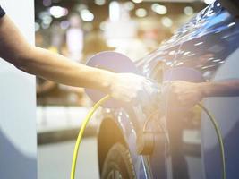 toma de mano del vehículo de carga eléctrica para recargar la batería del coche energía de energía limpia de color negro para el concepto futuro foto