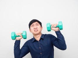 Man holding dumbbell feeling heavy and looking up at copy space photo