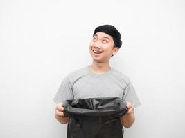 Man holding garbage smiling and looking above photo