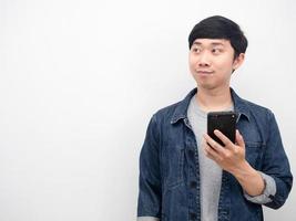 Handsome man jeans suit holding mobile phone and looking at copy space photo