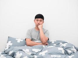 Asian man sit on the bed gesture bored looking at camera photo