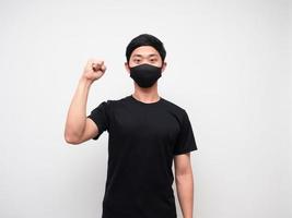 Cheerful man wearing protect mask show one fist up on white background photo