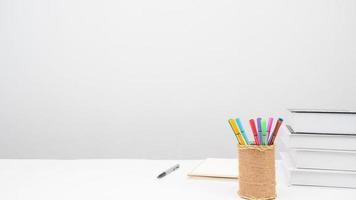 Pencil box pen books on the table copy space white background photo