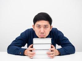 gesto de hombre aburrido de leer los libros sobre la mesa fondo blanco foto