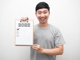 Man smiling showing document wood board with 2022 message and check list portrait photo