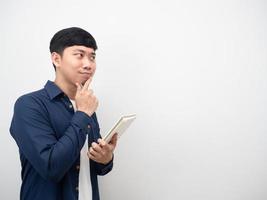 Man holding diary book gesture thinking and looking at copy space photo