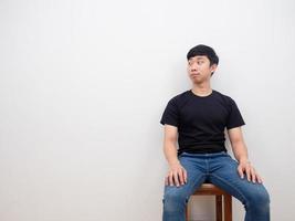 Handsome man asian sitting on chair looking at copy space left hand on white background photo