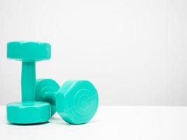 Dumbbell green color on the table white background copy space photo