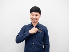 hombre sonriendo y tomando la tarjeta de crédito del bolsillo de la camisa foto