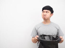 Man angry face holding garbage and looking at copy space photo