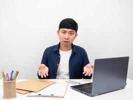 el empleado masculino sentado en el lugar de trabajo de la oficina se siente aburrido del trabajo en la mesa foto