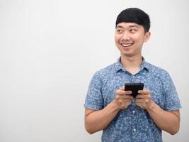 Asian man blue shirt holding smart phone happy smile and looking at copy space photo