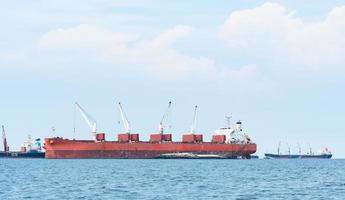 Large ship red color with big crane in the blue ocean and blue sky landscape,Industrial boat in the sea logistic concept photo