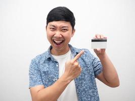 El hombre apunta con el dedo a la tarjeta de crédito retrato de emoción feliz foto