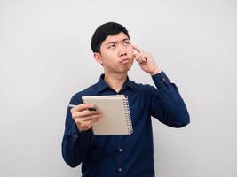 Man holding pen and diary and thinking about work photo