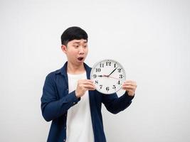Asian man feeling shocked at face looking at clock in his hand late concept on white background photo