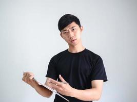 Asian young man holding wood clipboard and silver pen in hand serious face look at camera on white isolated,Work concept photo