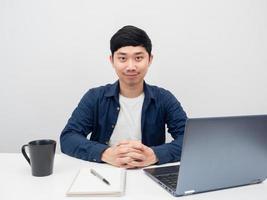 el hombre de negocios se sienta a trabajar en el escritorio con una sonrisa, el hombre se sienta en el lugar de trabajo foto