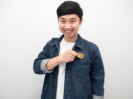 Portrait asian man smile and keep bitcoin in his pocket jeans photo