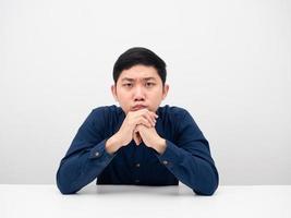 Asian man sitting at the table feeling worry about something and looking at you serious face photo