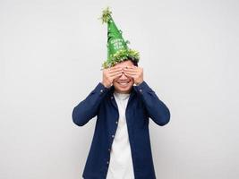 Man wearing green hat close his eyes celebration new year concept photo