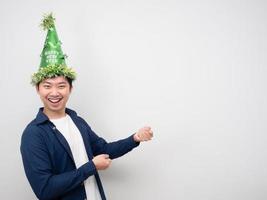 hombre asiático con sombrero verde gesto alegre tirar de la cuerda espacio de copia foto