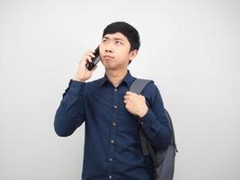 Man with backpack talking with mobile phone and thoughtful photo