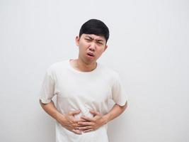 Man stomach ache touch his belly unhappy face on white background photo