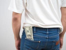 Cerrar la parte posterior del hombre dinero dólar en pantalones jean bolsillo retrato fondo blanco. foto