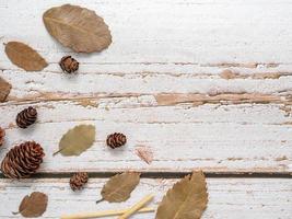 Dry leaf with pine cones on wold wooden top view copy space autumn concept photo