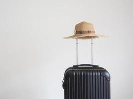Vintage hat above luggage black color on white isolated space photo