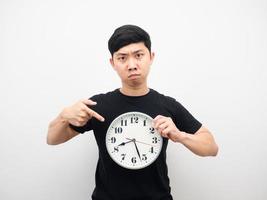 Man point finger at clock in hand feeling angry photo