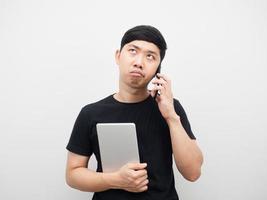 Man holding tablet with talking mobile phone gesture bored photo