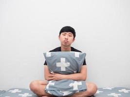 Man sit on the bed hug pillow feeling bored photo