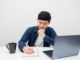 Man writing at notebook on the desk with laptop white background photo