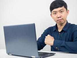 hombre trabajador con gesto de laptop confiado y mirando a la cámara foto