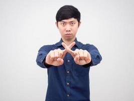 Asian man show cross finger hand with serious face white background