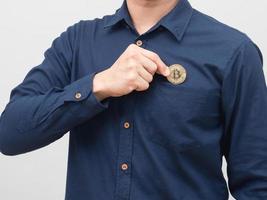 Closeup man hand pick up golden bitcoin from his shirt pocket portrait white background photo