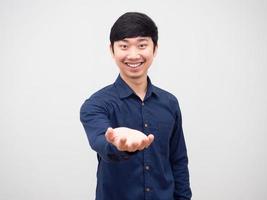 Cheerful man smile and show one hand empty up on white background photo