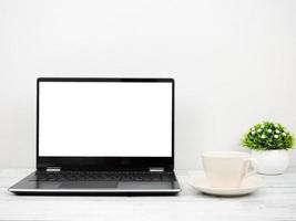 Laptop white screen with coffee cup and vase minimal on wooden table workspace concept photo
