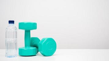 Dumbbell with water bottle on the table white background copy space photo