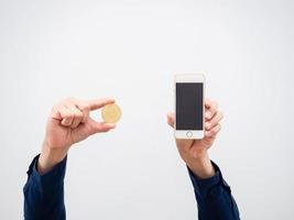 Closeup hand holding golden bitcoin coin and mobile phone in hand on white isolated background photo