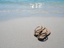 Woman shoe on the beach and blue ocean in natural copy space photo