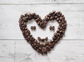 Coffee seed face smile happy on wood background top view idea coffee concept copy space photo